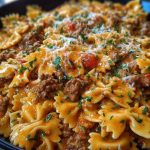 Cajun Cream Cheese Alfredo Bowties with Spiced Ground Beef Turn up the comfort with this flavor-packed Cajun Cream Cheese Alfredo Bowties with Spiced Ground Beef. This dish is all about indulgence: tender bowtie pasta enveloped in a rich, creamy cheese sauce, kicked up with Cajun spices and paired with hearty, well-seasoned beef. Whether it’s a cozy weeknight dinner or a crowd-pleasing meal for guests, this skillet creation delivers bold Southern flair with every bite. The best part? It all comes together in one pan. That means less mess and more flavor mingling between the pasta, meat, and cheesy sauce. It’s savory, creamy, and just the right amount of spicy—a guaranteed repeat recipe in your kitchen. ## Preparation Phase & Tools to Use (Essential Tools and Equipment, Plus Their Importance) Before diving in, make sure your kitchen is prepped with the right tools: * **Large Skillet or Sauté Pan**: This is the star of your setup. A wide skillet ensures even cooking and room to toss the pasta and sauce together without crowding. * **Wooden Spoon or Silicone Spatula**: Ideal for stirring the beef as it browns and for gently folding the creamy sauce into the pasta. * **Medium Pot**: Used to cook the bowtie pasta until al dente. It should be large enough for boiling without spillover. * **Colander**: Necessary for draining the pasta, especially if you're not cooking it directly in the skillet. * **Microplane or Cheese Grater**: If you’re using freshly shredded cheese (recommended!), this tool helps achieve a smooth melt. Setting yourself up with these essentials will make the cooking process smooth, efficient, and more enjoyable. --- ## Ingredients for the Cajun Cream Cheese Alfredo Bowties with Spiced Ground Beef Each ingredient in this bold pasta dish plays a crucial role in building a deeply satisfying flavor: * **Bowtie Pasta (Farfalle)**: The perfect pasta shape to catch and hold onto the creamy sauce in every groove. * **Ground Beef**: Hearty and flavorful, it gives the dish its richness and comforting bite. * **Cream Cheese**: Adds tang and luxurious creaminess to balance the Cajun spices. * **Heavy Cream**: Essential for creating a silky, indulgent Alfredo base. * **Shredded Cheddar & Mozzarella Cheese**: This combo offers meltability and flavor depth. * **Cajun Seasoning**: The heart of the flavor—smoky, spicy, and bold. * **Garlic (Minced)**: Adds a warm, aromatic backbone to the beef and sauce. * **Onion Powder & Paprika**: Boosts the savoriness and enhances the color of the sauce. * **Butter**: Used to enrich the base and help melt the cheeses smoothly. * **Fresh Parsley (optional)**: For a touch of color and freshness at the end. --- ## How To Make the Cajun Cream Cheese Alfredo Bowties with Spiced Ground Beef ### Step 1: Brown the Beef In a large skillet over medium-high heat, cook the ground beef until fully browned. Break it into crumbles and season it with half of the Cajun seasoning. Drain excess fat if needed. ### Step 2: Boil the Pasta While the beef cooks, bring a medium pot of salted water to a boil. Cook the bowtie pasta until al dente, then drain and set aside. ### Step 3: Make the Creamy Base Reduce the skillet to medium heat. Add butter and minced garlic to the beef. Sauté for 1-2 minutes, then stir in the cream cheese until melted. ### Step 4: Create the Alfredo Sauce Pour in the heavy cream and sprinkle in the remaining Cajun seasoning, onion powder, and paprika. Stir gently, letting it simmer for a few minutes until the sauce thickens slightly. ### Step 5: Combine Pasta and Sauce Add the cooked bowtie pasta into the skillet and toss to coat it thoroughly in the sauce. Sprinkle in the shredded cheddar and mozzarella, stirring until melted and gooey. ### Step 6: Final Touch Turn off the heat and top with a little extra cheese if desired. Garnish with chopped parsley before serving for a vibrant finish. --- ## Best Ways to Serve and Store This Creamy Cajun Pasta This pasta is at its absolute best when served hot and fresh out of the skillet. The cheeses are still melty, the sauce creamy, and the bowties tender but firm. Pair it with a slice of crusty garlic bread or a crisp green salad to round out your meal. A drizzle of hot sauce or a squeeze of lemon can add extra zing for spice-lovers. For storing leftovers, let the pasta cool completely and transfer to an airtight container. It will keep in the refrigerator for up to 3 days. When reheating, add a splash of cream or milk to restore the sauce's smooth texture. Avoid microwaving for too long to prevent the cheese from separating. ## Frequently Asked Questions ### What can I substitute for ground beef? Ground turkey, chicken, or even plant-based meat alternatives work well. Just season them generously to maintain that Cajun punch. ### Is this dish very spicy? That depends on your Cajun seasoning blend. Start with less if you're spice-sensitive, and add more to taste. ### Can I make it ahead of time? You can prep the beef and sauce a day ahead. Cook the pasta fresh and combine everything when you're ready to serve. ### Does cream cheese belong in Alfredo? Traditionally, no—but in this version, cream cheese adds a velvety tang that thickens and modernizes the sauce beautifully. ### Can I use a different type of pasta? Absolutely! Penne, rotini, or shells will also hold the creamy sauce well. ### What kind of cheddar is best? Sharp cheddar brings bold flavor, but a mild or medium cheddar will melt smoother. A mix of both is ideal. --- ## Want More Pasta Dinner Ideas? If this Cajun Cream Cheese Alfredo Bowties with Spiced Ground Beef won you over, here are some other irresistible pasta favorites from Life With Olivia: * [Creamy Garlic Butter Chicken Rotini in Parmesan Sauce](https://lifewitholivia.com/creamy-garlic-butter-chicken-rotini-in-parmesan-sauce/) – a silky, comforting dinner option. * [Spicy Cajun Garlic Butter Sausage Pasta](https://lifewitholivia.com/spicy-cajun-garlic-butter-sausage-pasta/) – perfect if you love heat and bold sausage flavor. * [Cheesy Garlic Chicken and Broccoli Pasta](https://lifewitholivia.com/cheesy-garlic-chicken-and-broccoli-pasta/) – for a family-friendly classic with veggies built in. * [Creamy Spicy Buffalo Ranch Pasta](https://lifewitholivia.com/creamy-spicy-buffalo-ranch-pasta/) – a fiery twist with a ranchy kick. * [Beef and Bowtie Pasta with Alfredo Sauce](https://lifewitholivia.com/beef-and-bowtie-pasta-with-alfredo-sauce/) – another rich, beefy bowtie favorite to bookmark. ## Save This Recipe for Later 📌 Save this recipe to your Pinterest dinner board so you can come back to it any time. And let me know in the comments how yours turned out. Did you add more spice? Swap in a different cheese? Maybe try it with shrimp? I love seeing how these recipes evolve in your kitchens. Share your thoughts, tweaks, or questions below—we’re all about building flavor together. For more daily recipe inspiration, follow along on my Pinterest: [Life With Olivia](https://www.pinterest.com/scherer29/) ---