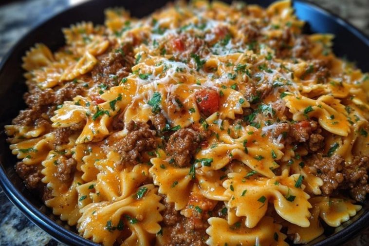 Cajun Cream Cheese Alfredo Bowties with Spiced Ground Beef Turn up the comfort with this flavor-packed Cajun Cream Cheese Alfredo Bowties with Spiced Ground Beef. This dish is all about indulgence: tender bowtie pasta enveloped in a rich, creamy cheese sauce, kicked up with Cajun spices and paired with hearty, well-seasoned beef. Whether it’s a cozy weeknight dinner or a crowd-pleasing meal for guests, this skillet creation delivers bold Southern flair with every bite. The best part? It all comes together in one pan. That means less mess and more flavor mingling between the pasta, meat, and cheesy sauce. It’s savory, creamy, and just the right amount of spicy—a guaranteed repeat recipe in your kitchen. ## Preparation Phase & Tools to Use (Essential Tools and Equipment, Plus Their Importance) Before diving in, make sure your kitchen is prepped with the right tools: * **Large Skillet or Sauté Pan**: This is the star of your setup. A wide skillet ensures even cooking and room to toss the pasta and sauce together without crowding. * **Wooden Spoon or Silicone Spatula**: Ideal for stirring the beef as it browns and for gently folding the creamy sauce into the pasta. * **Medium Pot**: Used to cook the bowtie pasta until al dente. It should be large enough for boiling without spillover. * **Colander**: Necessary for draining the pasta, especially if you're not cooking it directly in the skillet. * **Microplane or Cheese Grater**: If you’re using freshly shredded cheese (recommended!), this tool helps achieve a smooth melt. Setting yourself up with these essentials will make the cooking process smooth, efficient, and more enjoyable. --- ## Ingredients for the Cajun Cream Cheese Alfredo Bowties with Spiced Ground Beef Each ingredient in this bold pasta dish plays a crucial role in building a deeply satisfying flavor: * **Bowtie Pasta (Farfalle)**: The perfect pasta shape to catch and hold onto the creamy sauce in every groove. * **Ground Beef**: Hearty and flavorful, it gives the dish its richness and comforting bite. * **Cream Cheese**: Adds tang and luxurious creaminess to balance the Cajun spices. * **Heavy Cream**: Essential for creating a silky, indulgent Alfredo base. * **Shredded Cheddar & Mozzarella Cheese**: This combo offers meltability and flavor depth. * **Cajun Seasoning**: The heart of the flavor—smoky, spicy, and bold. * **Garlic (Minced)**: Adds a warm, aromatic backbone to the beef and sauce. * **Onion Powder & Paprika**: Boosts the savoriness and enhances the color of the sauce. * **Butter**: Used to enrich the base and help melt the cheeses smoothly. * **Fresh Parsley (optional)**: For a touch of color and freshness at the end. --- ## How To Make the Cajun Cream Cheese Alfredo Bowties with Spiced Ground Beef ### Step 1: Brown the Beef In a large skillet over medium-high heat, cook the ground beef until fully browned. Break it into crumbles and season it with half of the Cajun seasoning. Drain excess fat if needed. ### Step 2: Boil the Pasta While the beef cooks, bring a medium pot of salted water to a boil. Cook the bowtie pasta until al dente, then drain and set aside. ### Step 3: Make the Creamy Base Reduce the skillet to medium heat. Add butter and minced garlic to the beef. Sauté for 1-2 minutes, then stir in the cream cheese until melted. ### Step 4: Create the Alfredo Sauce Pour in the heavy cream and sprinkle in the remaining Cajun seasoning, onion powder, and paprika. Stir gently, letting it simmer for a few minutes until the sauce thickens slightly. ### Step 5: Combine Pasta and Sauce Add the cooked bowtie pasta into the skillet and toss to coat it thoroughly in the sauce. Sprinkle in the shredded cheddar and mozzarella, stirring until melted and gooey. ### Step 6: Final Touch Turn off the heat and top with a little extra cheese if desired. Garnish with chopped parsley before serving for a vibrant finish. --- ## Best Ways to Serve and Store This Creamy Cajun Pasta This pasta is at its absolute best when served hot and fresh out of the skillet. The cheeses are still melty, the sauce creamy, and the bowties tender but firm. Pair it with a slice of crusty garlic bread or a crisp green salad to round out your meal. A drizzle of hot sauce or a squeeze of lemon can add extra zing for spice-lovers. For storing leftovers, let the pasta cool completely and transfer to an airtight container. It will keep in the refrigerator for up to 3 days. When reheating, add a splash of cream or milk to restore the sauce's smooth texture. Avoid microwaving for too long to prevent the cheese from separating. ## Frequently Asked Questions ### What can I substitute for ground beef? Ground turkey, chicken, or even plant-based meat alternatives work well. Just season them generously to maintain that Cajun punch. ### Is this dish very spicy? That depends on your Cajun seasoning blend. Start with less if you're spice-sensitive, and add more to taste. ### Can I make it ahead of time? You can prep the beef and sauce a day ahead. Cook the pasta fresh and combine everything when you're ready to serve. ### Does cream cheese belong in Alfredo? Traditionally, no—but in this version, cream cheese adds a velvety tang that thickens and modernizes the sauce beautifully. ### Can I use a different type of pasta? Absolutely! Penne, rotini, or shells will also hold the creamy sauce well. ### What kind of cheddar is best? Sharp cheddar brings bold flavor, but a mild or medium cheddar will melt smoother. A mix of both is ideal. --- ## Want More Pasta Dinner Ideas? If this Cajun Cream Cheese Alfredo Bowties with Spiced Ground Beef won you over, here are some other irresistible pasta favorites from Life With Olivia: * [Creamy Garlic Butter Chicken Rotini in Parmesan Sauce](https://lifewitholivia.com/creamy-garlic-butter-chicken-rotini-in-parmesan-sauce/) – a silky, comforting dinner option. * [Spicy Cajun Garlic Butter Sausage Pasta](https://lifewitholivia.com/spicy-cajun-garlic-butter-sausage-pasta/) – perfect if you love heat and bold sausage flavor. * [Cheesy Garlic Chicken and Broccoli Pasta](https://lifewitholivia.com/cheesy-garlic-chicken-and-broccoli-pasta/) – for a family-friendly classic with veggies built in. * [Creamy Spicy Buffalo Ranch Pasta](https://lifewitholivia.com/creamy-spicy-buffalo-ranch-pasta/) – a fiery twist with a ranchy kick. * [Beef and Bowtie Pasta with Alfredo Sauce](https://lifewitholivia.com/beef-and-bowtie-pasta-with-alfredo-sauce/) – another rich, beefy bowtie favorite to bookmark. ## Save This Recipe for Later 📌 Save this recipe to your Pinterest dinner board so you can come back to it any time. And let me know in the comments how yours turned out. Did you add more spice? Swap in a different cheese? Maybe try it with shrimp? I love seeing how these recipes evolve in your kitchens. Share your thoughts, tweaks, or questions below—we’re all about building flavor together. For more daily recipe inspiration, follow along on my Pinterest: [Life With Olivia](https://www.pinterest.com/scherer29/) ---